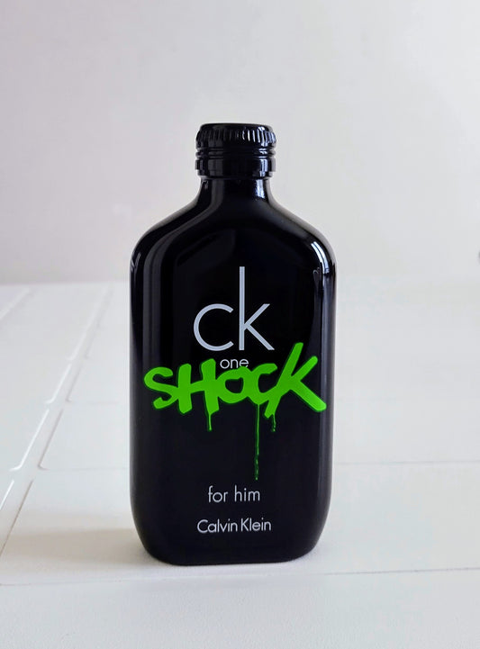 Black bottle of Calvin Klein 'ck one shock' for him on a white background