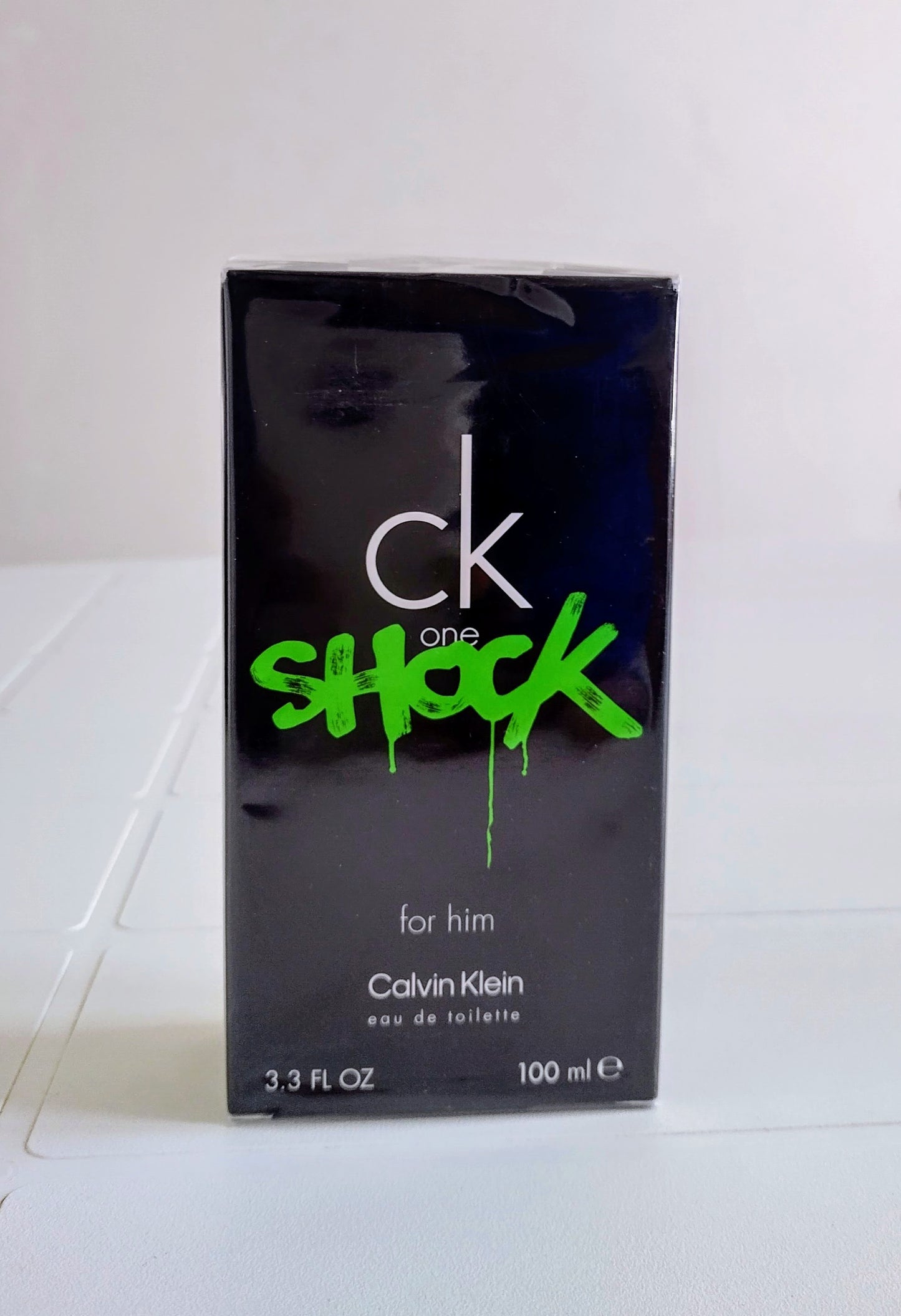 Calvin Klein CK One Shock perfume packaging on a white surface
