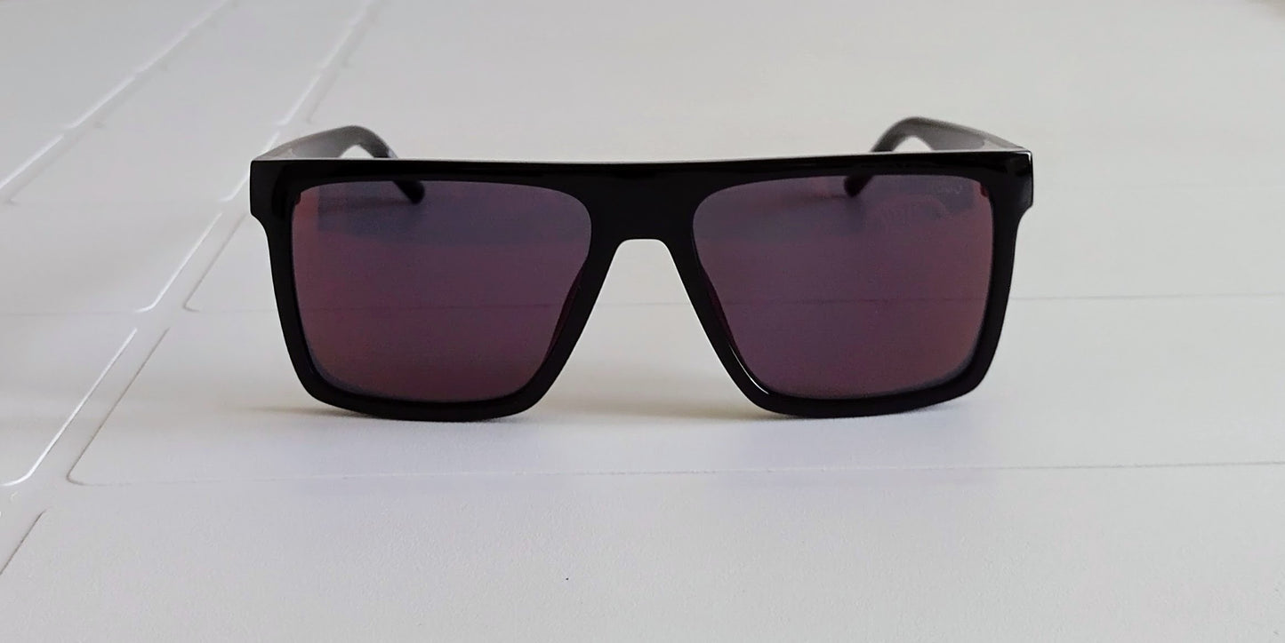 Black sunglasses with purple lenses on a white surface